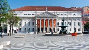 Un bâtiment historique à l’architecture classique, doté d’une fontaine centrale et d’un sol pavé avec des motifs décoratifs.