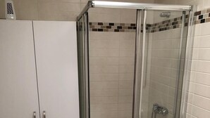 A bathroom with a glass-enclosed shower, a white toilet, and a green rug. - RESIDENTIAL JANDIA MARINA 111 (Morro Jable)