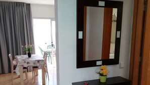 A room with a dining table, chairs, a console table with a mirror, and a potted plant. - RESIDENTIAL JANDIA MARINA 111 (Morro Jable)