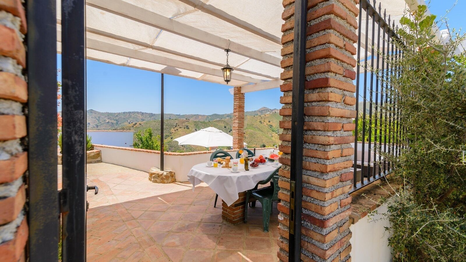 Une terrasse extérieure avec une table dressée pour le petit-déjeuner, offrant une vue sur un paysage magnifique.