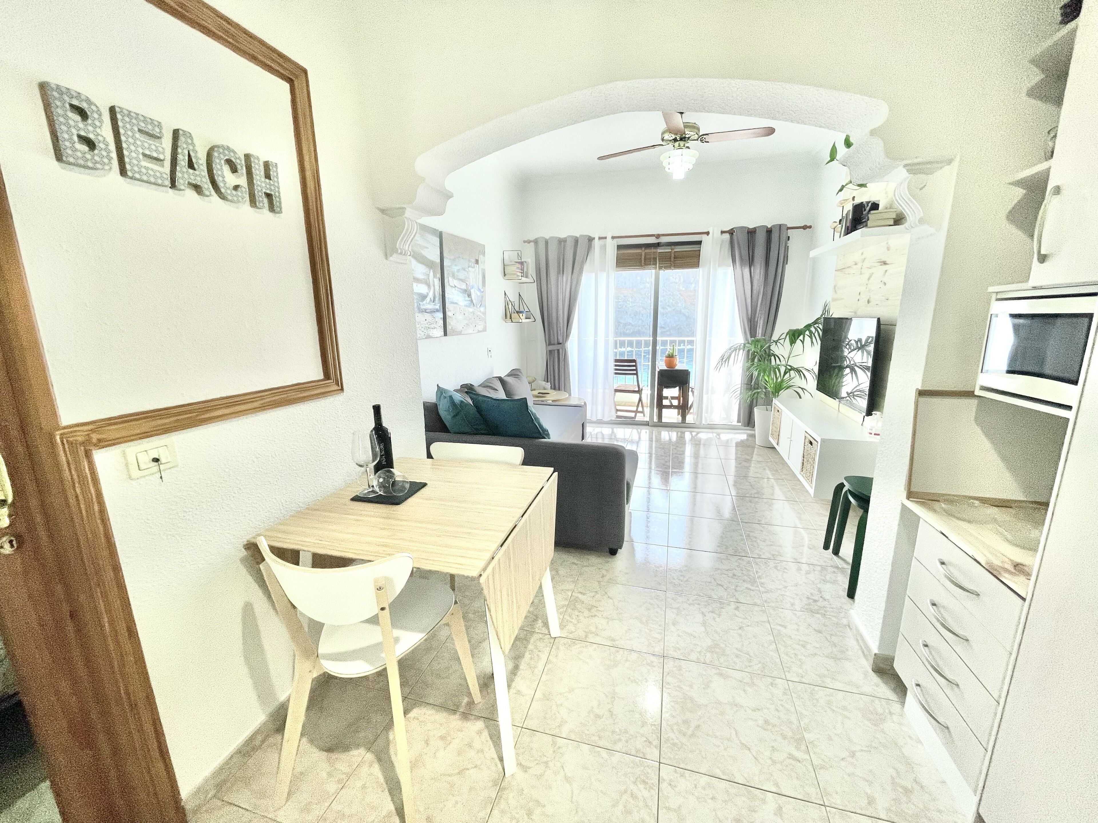 Un salon moderne comprenant un coin repas, une cuisine et un balcon avec vue.