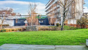En moderne bygning med fladt tag og en lille dam foran.