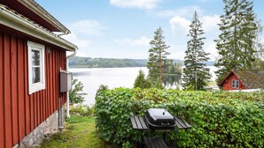 Una casa de madera roja con vistas a un lago y árboles.