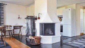 Una cocina moderna con chimenea de piedra, una estufa grande y un refrigerador.