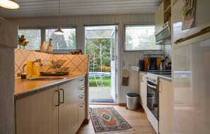 Enjoy cooking in this well-equipped kitchen with a central island, sink, stove, and window above the sink.