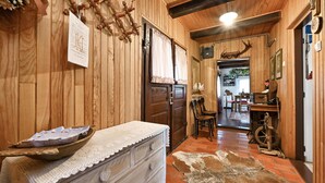 A wooden interior with a rustic decor, including a wooden wall, a lace-covered dresser, and a cowhide rug. - Gorgeous home in Kupljenovo (Kupljenovo)