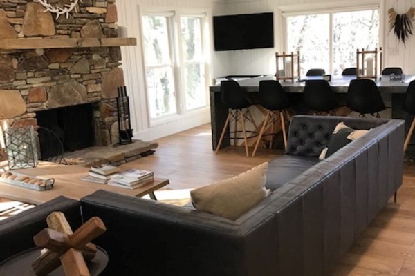 Upstairs living room with vaulted ceilings and panoramic lake views.