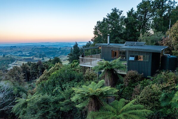 Une maison moderne dotée d’une terrasse offrant une vue sur une vallée.