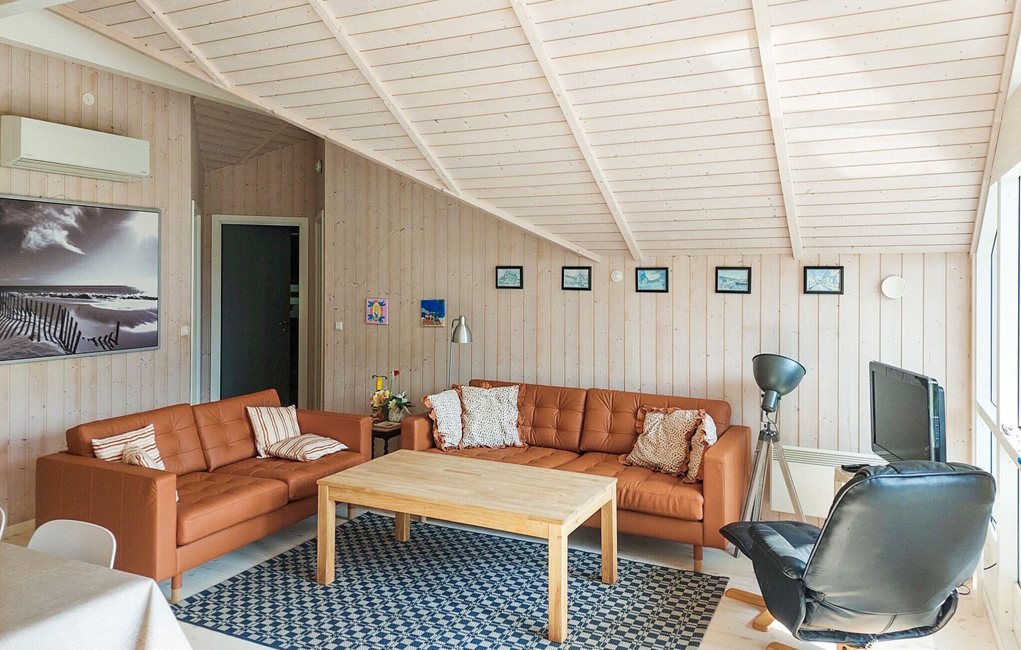 Un soggiorno accogliente con soffitto in legno, due divani, un tavolino da caffè e una TV.