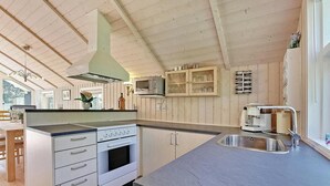 A kitchen with wooden cabinets, a built-in oven, a microwave, and a coffee maker.