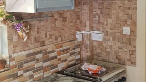 Cuina amb armaris de marbre, forlla a gas i forn integrat.