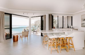 Una cucina moderna con zona bar, ampie finestre e vista sul mare.