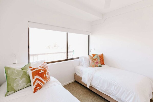 A bedroom with two beds, a window, and a view of the outside. - Mavis - Little Cove (Noosa Heads)