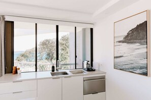 A modern kitchen with a large window, a sink, and a dishwasher. - Mavis - Little Cove (Noosa Heads)