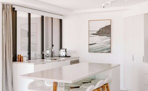 A modern kitchen with a large island, a double sink, and a large mirror. - Mavis - Little Cove (Noosa Heads)