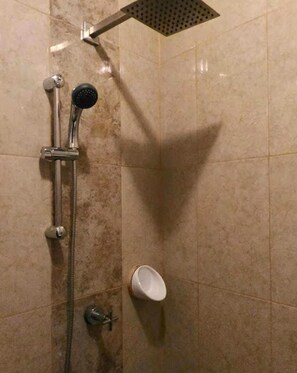 Een bad/douchecombinatie, een bidet, handdoeken, zeep