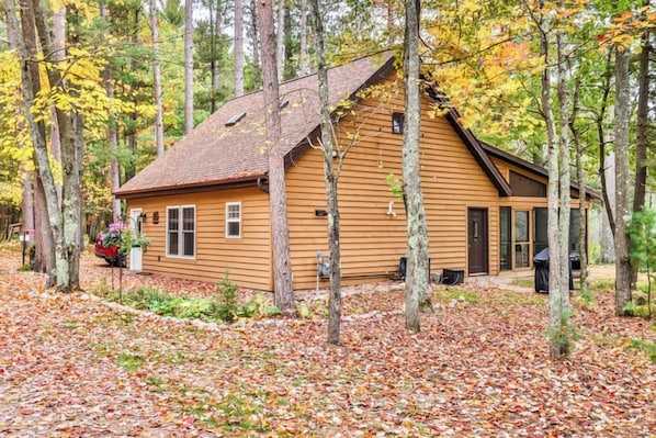 Una baita di legno circondata da alberi, con un portico coperto.