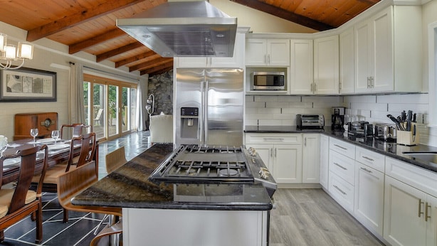 A modern kitchen with a central island, stainless steel appliances, and white cabinetry. - Skyline Retreat with Spectacular Bay Views (Oakland)