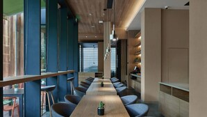 Une salle de conférence moderne, dotée d’une longue table, de nombreuses chaises et offrant une vue dégagée grâce à de grandes fenêtres.