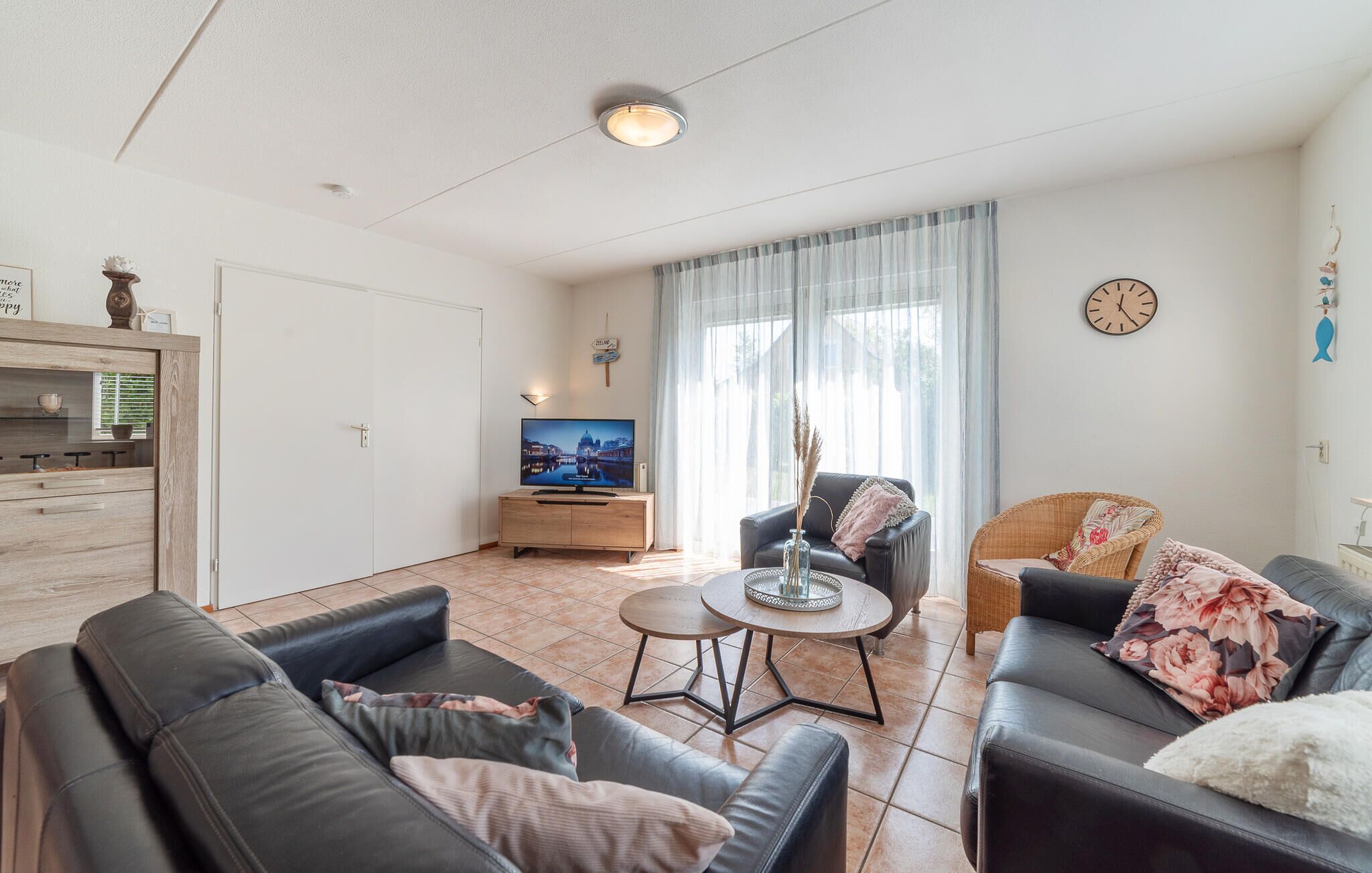 Een moderne woonkamer met een bank, een salontafel en een televisie.
