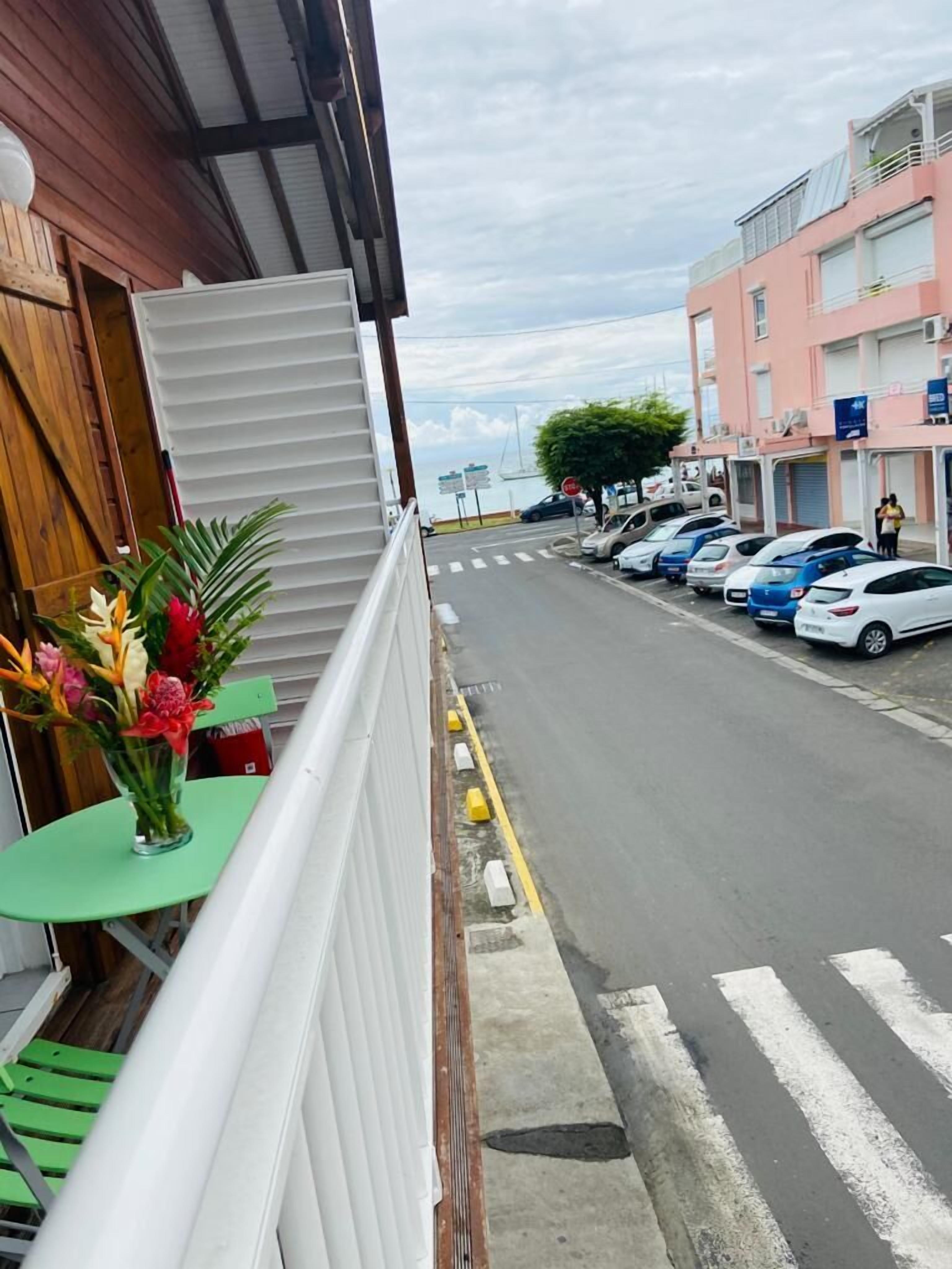 A balcony with a view of a street and parked cars.
