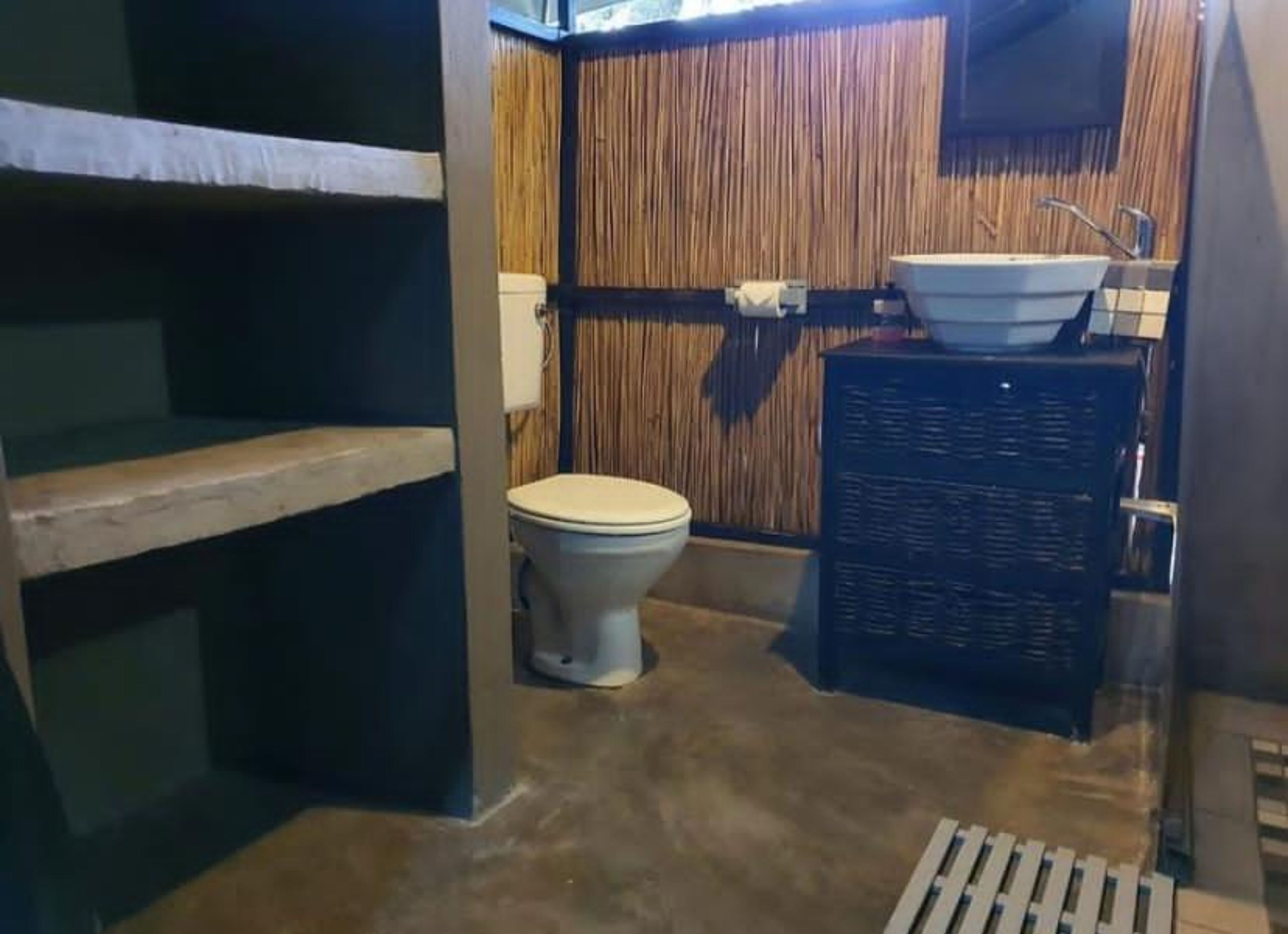 A compact bathroom with a toilet, a sink, and a shower area.