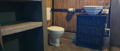 A compact bathroom with a toilet, a sink, and a shower area.