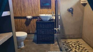 Un baño con inodoro, lavabo y ducha.