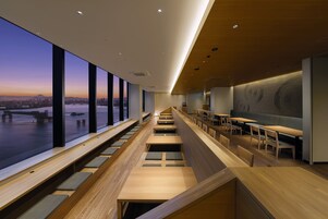 Un intérieur moderne avec des gradins et de grandes fenêtres offrant une vue sur la ville.