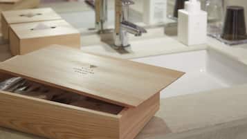 A bathroom with a wooden vanity, a mirror, and various toiletries.