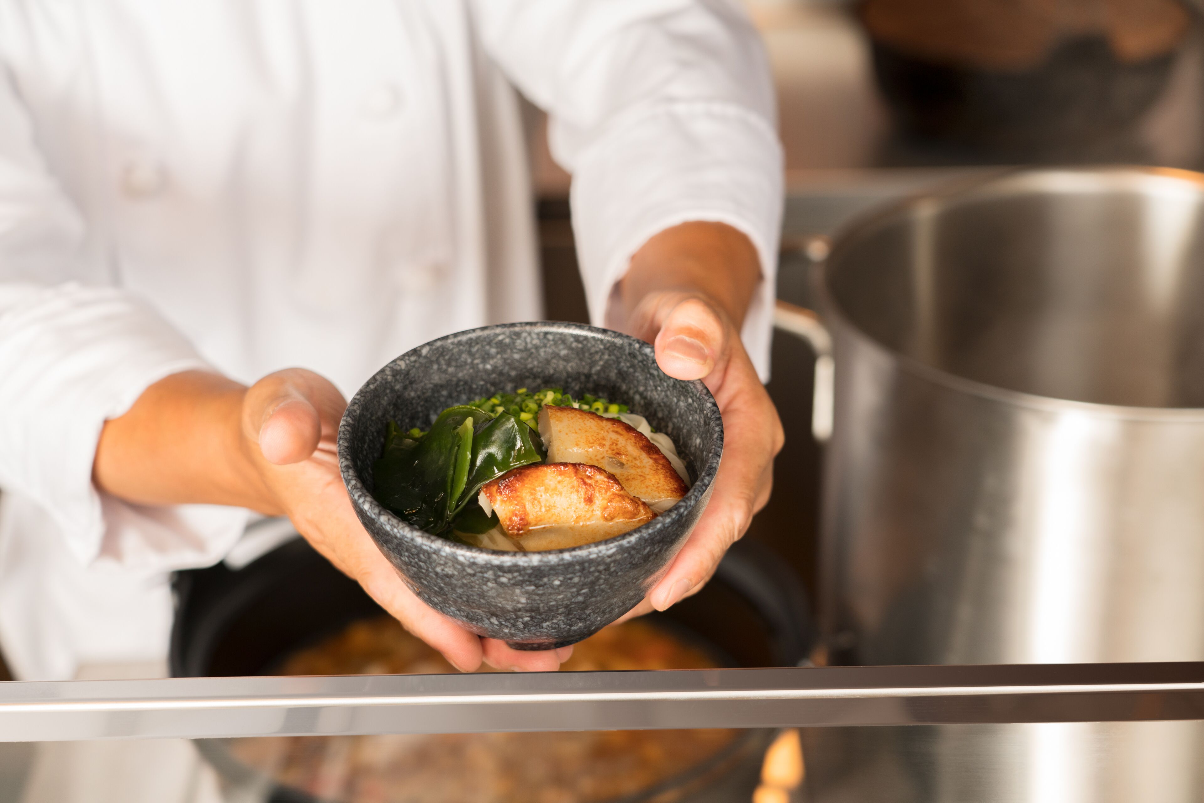 Un chef sosteniendo un tazón con comida.