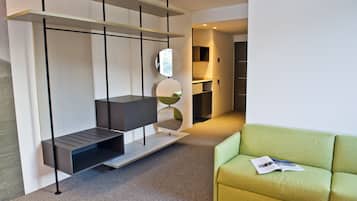 A modern room with a built-in bench, a green sofa, and a magazine on the sofa.