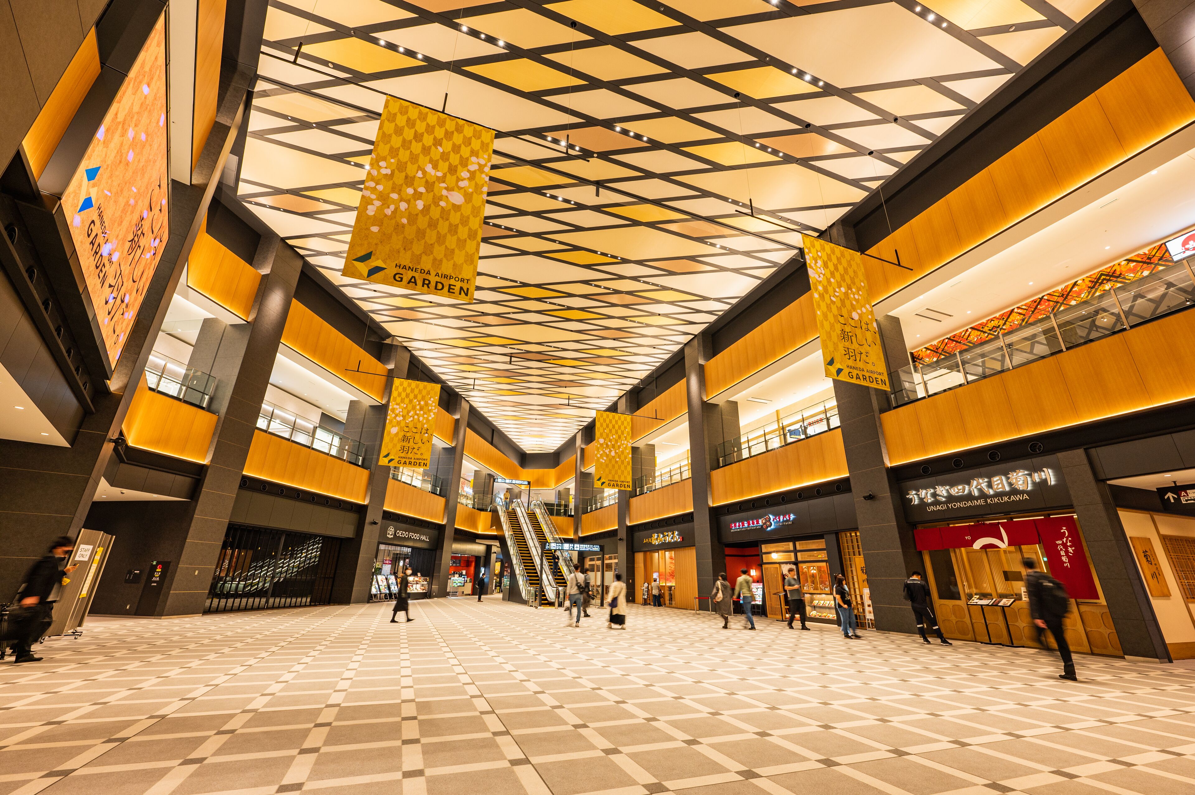 A spacious indoor area with a checkered floor, multiple levels, and a central escalator.