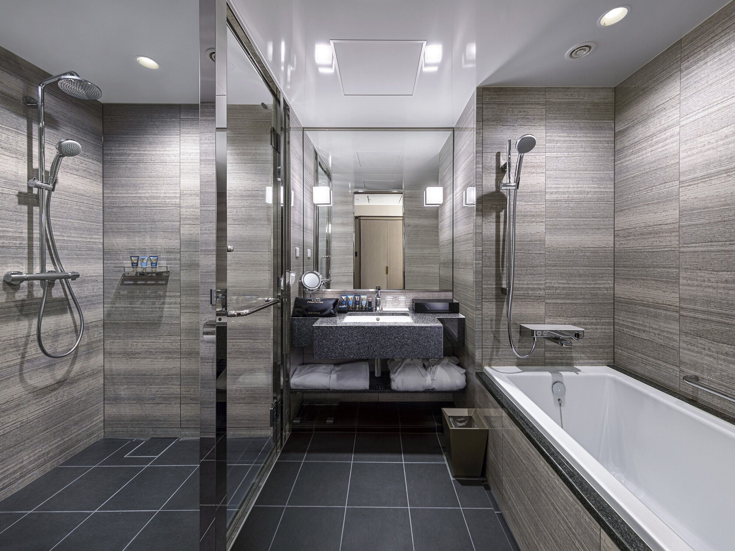Une salle de bain moderne dotée d’une douche à parois de verre, d’une baignoire sur pieds et d’un meuble-lavabo avec un miroir.