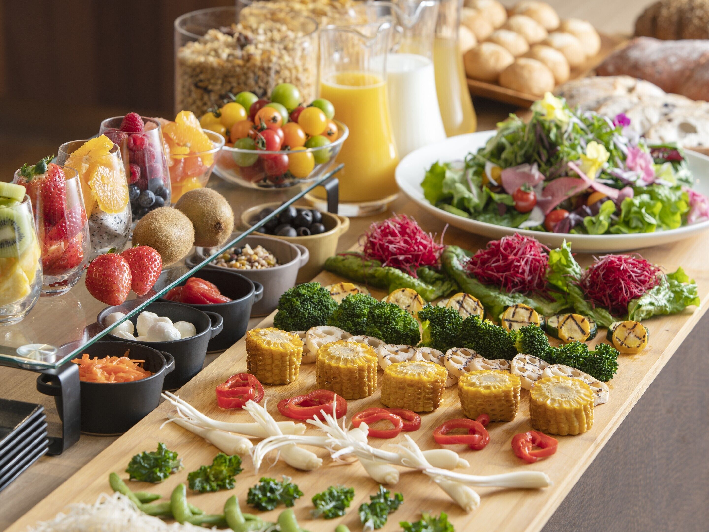 Un bufé con diversos platos, incluyendo frutas, verduras y ensaladas.