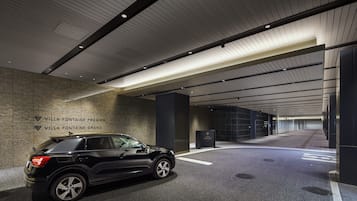 Ein schwarzer SUV steht in einer modernen, gut beleuchteten Tiefgarage mit sauber gefliestem Boden und hohen Decken mit Linienbeleuchtung.