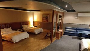 A hotel room with two beds, a seating area, and a large window.
