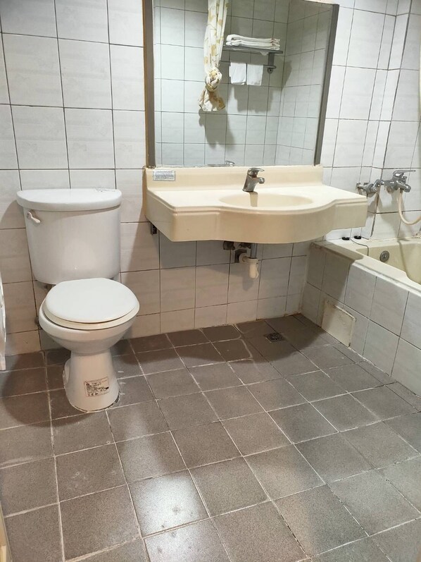 A bathroom with a toilet, sink, and bathtub.