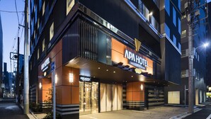 Een modern hotel met een opvallend bord, grote ramen en een goed verlichte ingang.