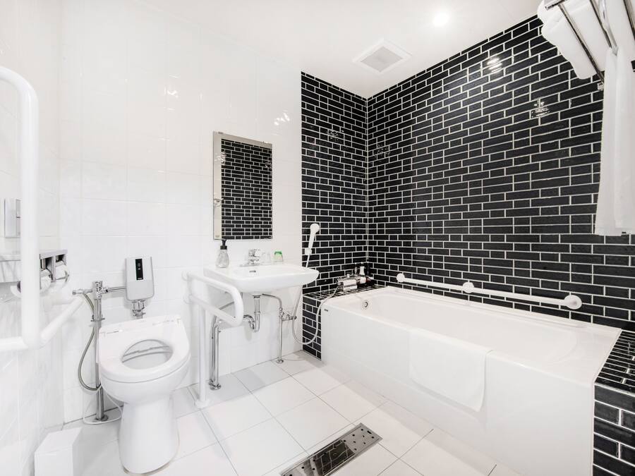 A modern bathroom with a white toilet, sink, and bathtub.