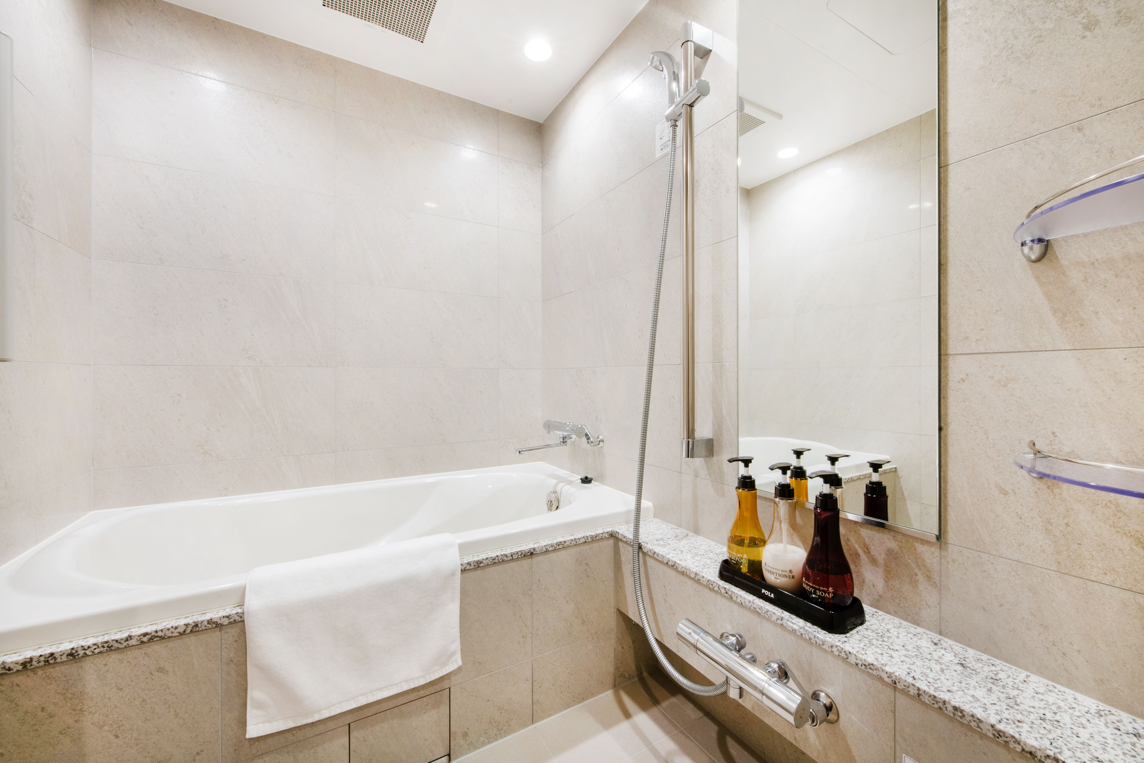 Un baño moderno con bañera, ducha y tocador con artículos de aseo.