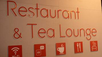 A wall with the text "Restaurant & Tea Lounge" and icons indicating Wi-Fi, a coffee cup, a fork and knife, and a chair.