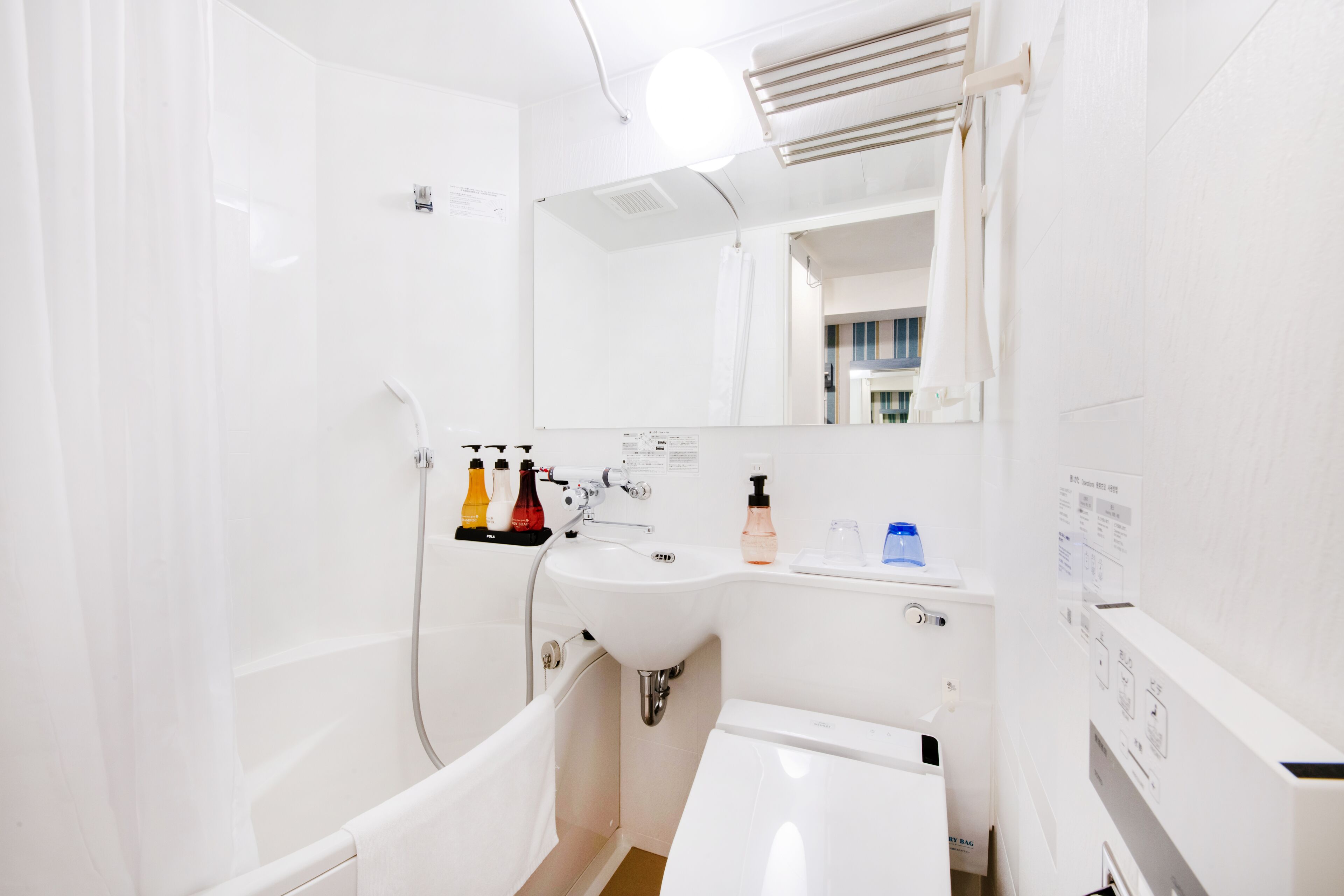 A modern bathroom with a bathtub, a sink, and a mirror.