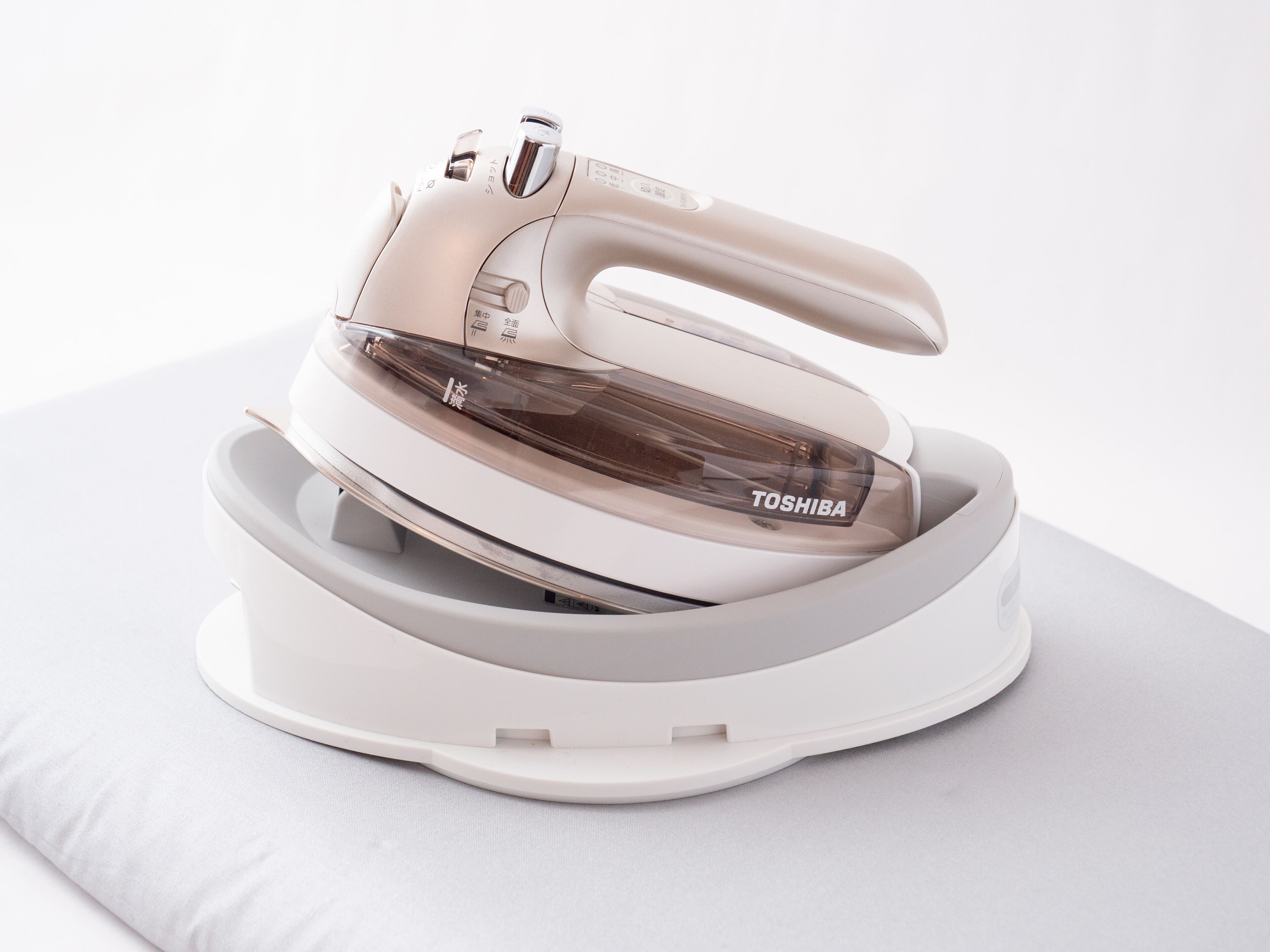 A white iron with a transparent water tank and the brand name 'TOSHIBA' visible.