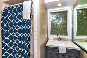 Tina con regadera, secadora de cabello, toallas 