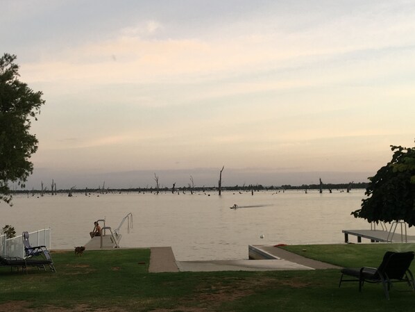 A lakeside view with a grassy area, a metal railing, and a few chairs. - Lakehouse At Mulwala - Two jetties and private boat ramp (Mulwala)