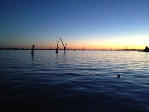 A calm body of water with trees in the foreground and a clear sky in the background. - Lakehouse At Mulwala - Two jetties and private boat ramp (Mulwala)