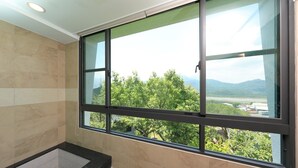 A bathroom with a large window, tiled walls, and a black countertop. - Five mountains and Three Water B&B (Shuili)