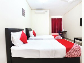 Ein Hotelzimmer mit zwei Betten, einem Schreibtisch, einem Stuhl, einem roten Vorhang und einer Klimaanlage.
