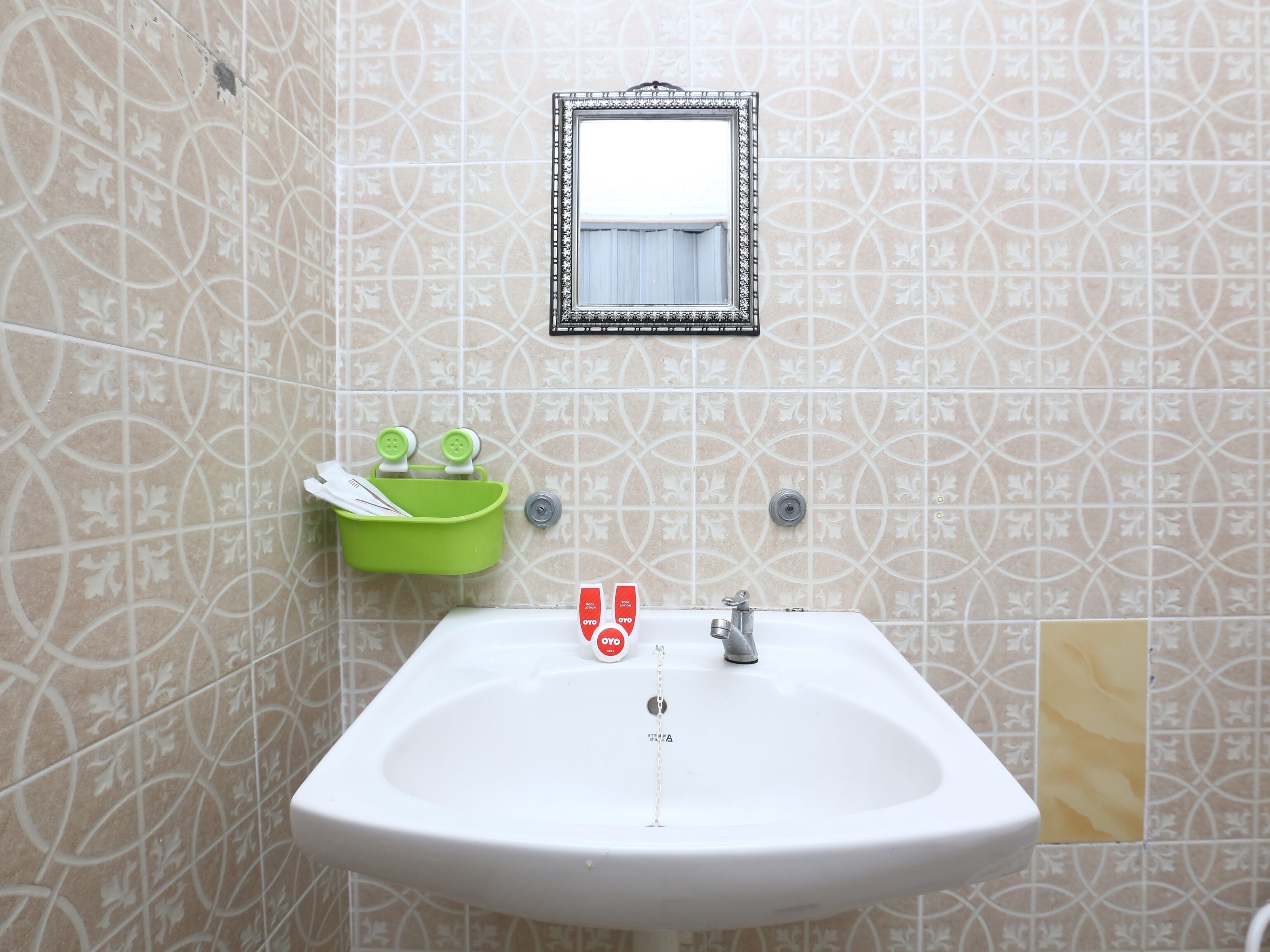 A bathroom with a white sink, a mirror, and a green soap dish.